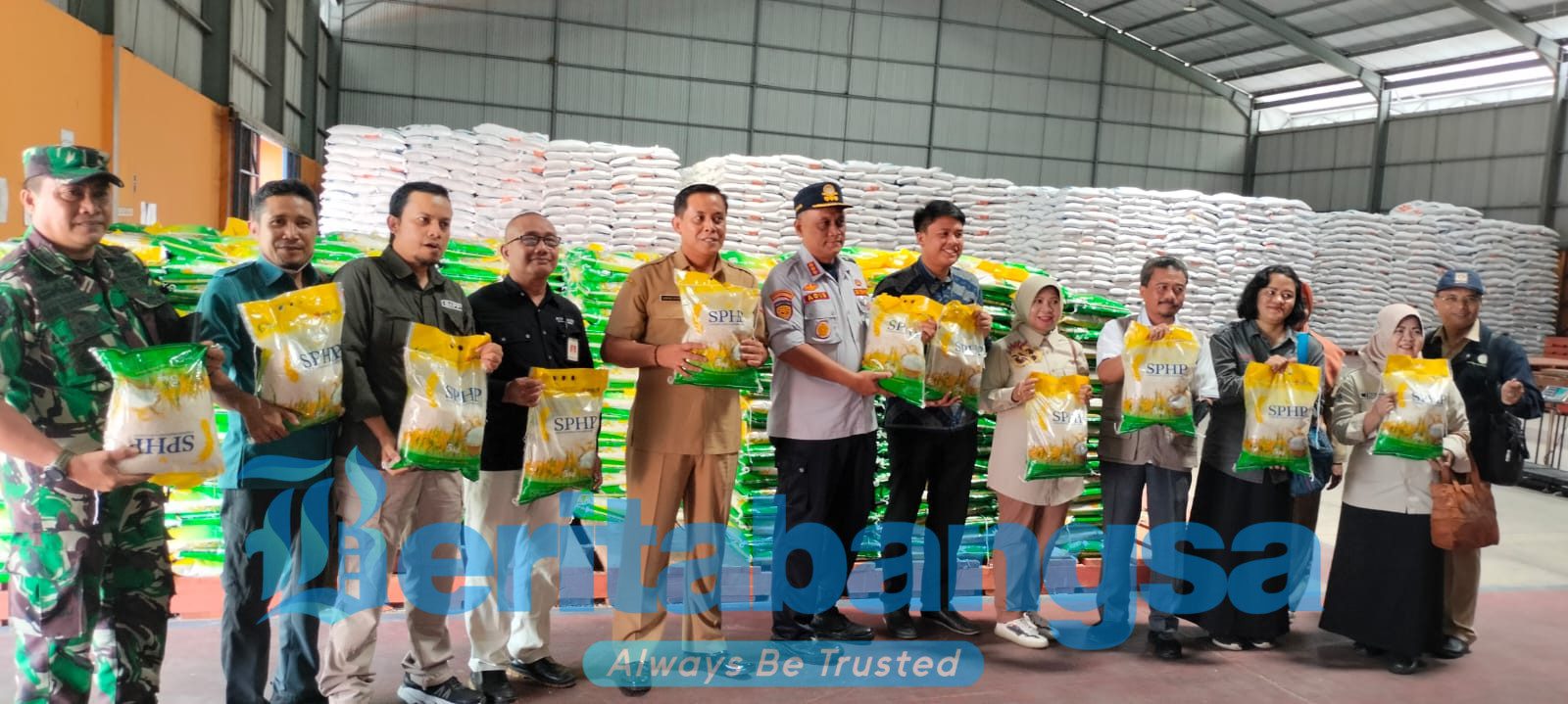 Caption: Kepala Disperindag Jember Bambang Saputro, menunjukkan beras Bulog di Gudang Bulog Mangli.